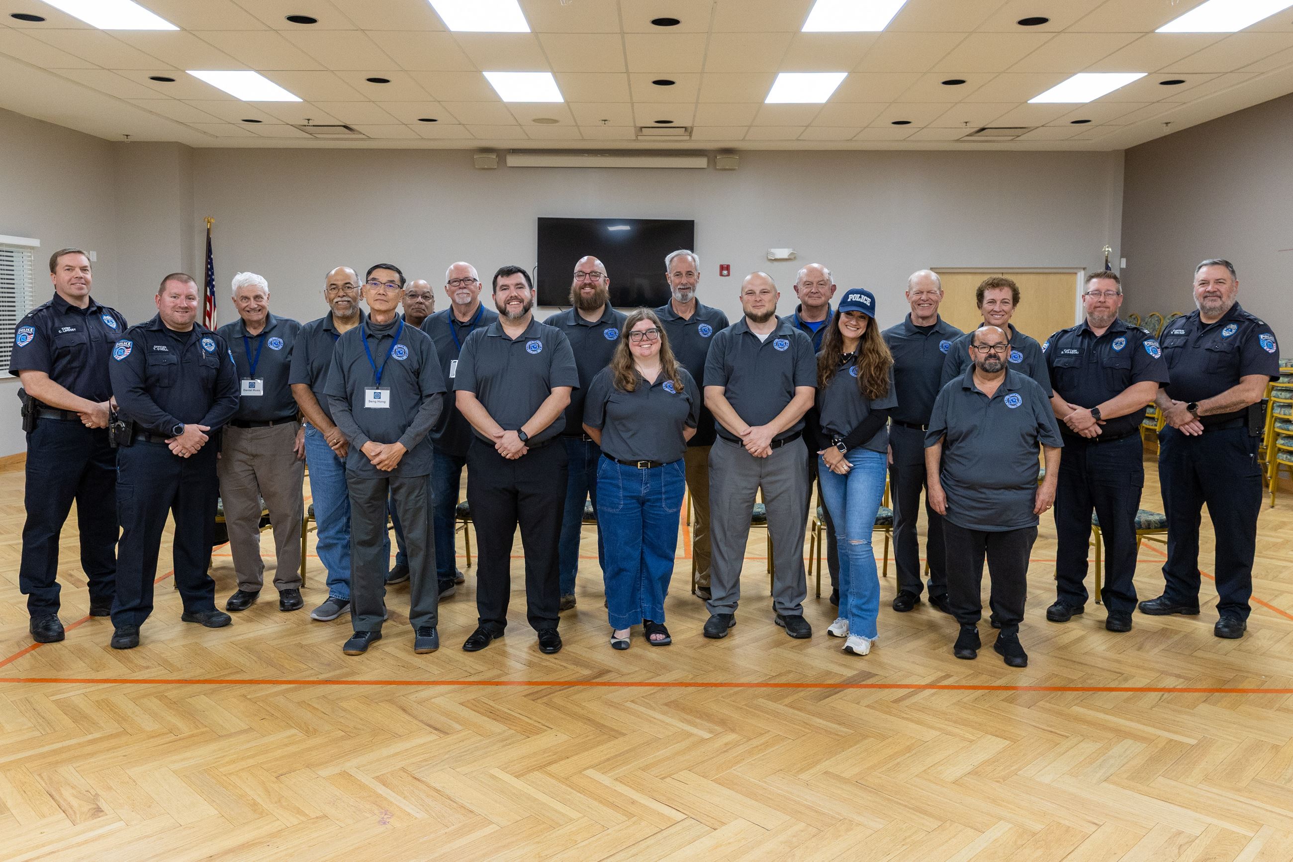 Group of police academy participants smiling.